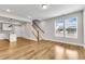 Bright living space features hardwood floors, stairs, and two windows at 1234 Coach Station Alley # 101, Raleigh, NC 27601