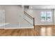 Open living space with hardwood floors, stairs, and a large window at 1234 Coach Station Alley # 101, Raleigh, NC 27601