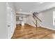 Open living space featuring hardwood floors, stairs, and view to the kitchen at 1234 Coach Station Alley # 101, Raleigh, NC 27601