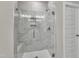 Modern shower showcasing marble-look tile, glass door, and convenient shower seat at 1234 Coach Station Alley # 101, Raleigh, NC 27601