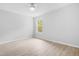 Minimalist bedroom featuring light wood floors, neutral paint, ceiling fan, and window to the outside at 1300 Hillbrow Ln # 204, Raleigh, NC 27615