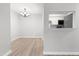 Bright dining room with a view of the kitchen through a pass-through, light wood floors, and chandelier at 1300 Hillbrow Ln # 204, Raleigh, NC 27615