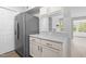 Bright kitchen featuring stainless steel refrigerator and white cabinets with marble countertops at 1300 Hillbrow Ln # 204, Raleigh, NC 27615
