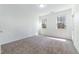 Bedroom featuring carpeted floors, ample natural light from two windows, and a neutral color palette at 1301 Elliott Ridge Ln, Morrisville, NC 27560