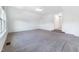Large bonus room with carpeted floors, ample natural light from windows, and stairs leading up at 1301 Elliott Ridge Ln, Morrisville, NC 27560