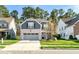 Charming two-story home with a brick and gray exterior, a well-manicured lawn, and an attached two-car garage at 1301 Elliott Ridge Ln, Morrisville, NC 27560