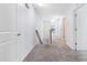 Hallway with neutral carpet, white walls, and railing leading upstairs at 1301 Elliott Ridge Ln, Morrisville, NC 27560