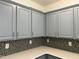 This kitchen boasts elegant blue cabinets, complemented by a stylish backsplash and sleek countertops at 1301 Elliott Ridge Ln, Morrisville, NC 27560
