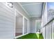 Covered outdoor porch with sliding glass door, railing, and artificial turf at 1301 Elliott Ridge Ln, Morrisville, NC 27560