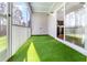 Covered outdoor porch with sliding glass door and artificial turf at 1301 Elliott Ridge Ln, Morrisville, NC 27560