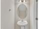 Practical powder room with a pedestal sink, oval mirror, and neutral walls for a clean, simple look at 1304 Cozart St # 258, Durham, NC 27704