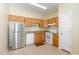 Functional kitchen with oak cabinets, white appliances, and durable flooring at 1311 Canyon Rock Ct # 105, Raleigh, NC 27610