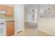 Kitchen area with wood cabinets, white appliances, opening to the living area at 1311 Canyon Rock Ct # 105, Raleigh, NC 27610