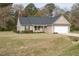 A quaint tan house with a lawn, American flag, and a two-car garage at 151 Goose Creek Cir, Dunn, NC 28334