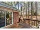 This wooden deck overlooks a wooded backyard with sliding glass door access to the brick home and has wooden railings at 1965 Wedgewood Dr, Sanford, NC 27332