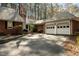 Well-maintained brick home featuring a lush front yard, an American flag, and a spacious driveway leading to a two-car garage at 1965 Wedgewood Dr, Sanford, NC 27332