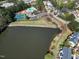 An aerial view showcases a lake, community pool, tennis courts, and surrounding homes at 200 Nottinghill Walk, Apex, NC 27502