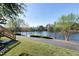 Expansive grassy backyard with a paved walkway alongside a lake at 200 Nottinghill Walk, Apex, NC 27502