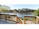 Deck overlooking lake with wood railing and stairs to the yard at 200 Nottinghill Walk, Apex, NC 27502