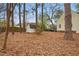 Large wooded backyard featuring a storage shed, mature trees, and a well-maintained lawn at 204 Arnold Ln, Fuquay Varina, NC 27526