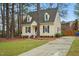 Inviting two-story home with manicured lawn, dormer windows, and a paved driveway at 204 Arnold Ln, Fuquay Varina, NC 27526