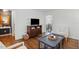 Open-concept living room with hardwood floors, comfortable seating, and view to dining area at 204 Arnold Ln, Fuquay Varina, NC 27526