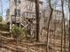 View of backyard with a multi-level wooden deck and stairs nestled among mature trees at 2217 Magnolia Tree Ln, Durham, NC 27703