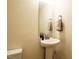 Half-bathroom with a pedestal sink, mirror and white ceramic toilet at 2217 Magnolia Tree Ln, Durham, NC 27703