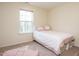 Cozy bedroom with a comfortable bed, natural light from the window, and neutral carpeting at 2217 Magnolia Tree Ln, Durham, NC 27703