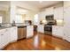 Charming kitchen features stainless steel appliances, granite countertops, and white cabinetry at 2217 Magnolia Tree Ln, Durham, NC 27703