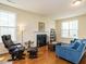 Cozy living room with hardwood floors, a fireplace, and an abundance of natural light at 2217 Magnolia Tree Ln, Durham, NC 27703