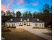 Elegant white home at twilight, highlighting its beautiful architecture and landscaping at 2223 Winston Cir, Apex, NC 27502
