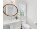 Classic powder room featuring a pedestal sink, round mirror, and neutral paint at 2223 Winston Cir, Apex, NC 27502