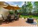 Landscaped backyard featuring a dining set with umbrella, trampoline, playground and wooded view at 240 Swann Trl, Clayton, NC 27527