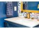 Stylish bathroom with blue walls, modern gold fixtures, and a decorative mirror adding a touch of elegance at 240 Swann Trl, Clayton, NC 27527