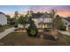 Stunning two-story home featuring manicured lawns and mature trees at sunset at 240 Swann Trl, Clayton, NC 27527