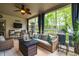 Inviting screened porch featuring comfortable seating, ceiling fan, and a view of the landscaped backyard at 240 Swann Trl, Clayton, NC 27527