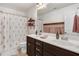 Bright bathroom features double sinks, modern fixtures, and a shower with floral curtains at 245 Naples Ln, Clayton, NC 27527
