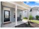 Charming covered front porch with a bench, the house number, and a black front door with glass at 245 Naples Ln, Clayton, NC 27527