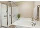Bright bathroom showcasing a soaking tub with glass shower and neutral decor at 2728 Cloud Mist Cir, Raleigh, NC 27614