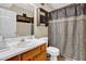 Bathroom with wooden vanity, a shower with patterned curtain, and a mirrored cabinet at 2816 Delco Ct, Raleigh, NC 27610