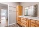 Bathroom vanity featuring granite counters, knotty pine cabinets, and a large mirror at 286 Sea Mist Dr, Sanford, NC 27332