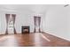 Cozy living room with a fireplace, hardwood floors, two large windows, and neutral walls at 286 Sea Mist Dr, Sanford, NC 27332