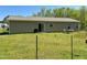 Fenced backyard with a lawn, a patio with outdoor seating, and verdant surroundings in a natural setting at 30 Golden Poppy Ln, Youngsville, NC 27596