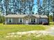 Charming single-story home featuring a manicured lawn, white shutters, and a welcoming front porch at 30 Golden Poppy Ln, Youngsville, NC 27596