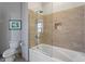 Clean bathroom with a shower-tub combo, neutral tile, and a modern toilet with decorative artwork at 317 W Morgan St # 317, Raleigh, NC 27601