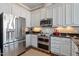 Modern kitchen with stainless steel refrigerator and appliances, complemented by granite countertops and backsplash at 317 W Morgan St # 317, Raleigh, NC 27601