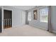 Well-lit bedroom featuring two windows, plush carpeting, and neutral-toned walls at 323 E Stratford Dr, Henderson, NC 27537