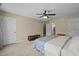 Spacious bedroom with plush carpeting, ceiling fan, and natural light from the windows at 323 E Stratford Dr, Henderson, NC 27537