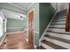 Bright hallway leading to staircase with wooden door and hardwood flooring at 323 E Stratford Dr, Henderson, NC 27537